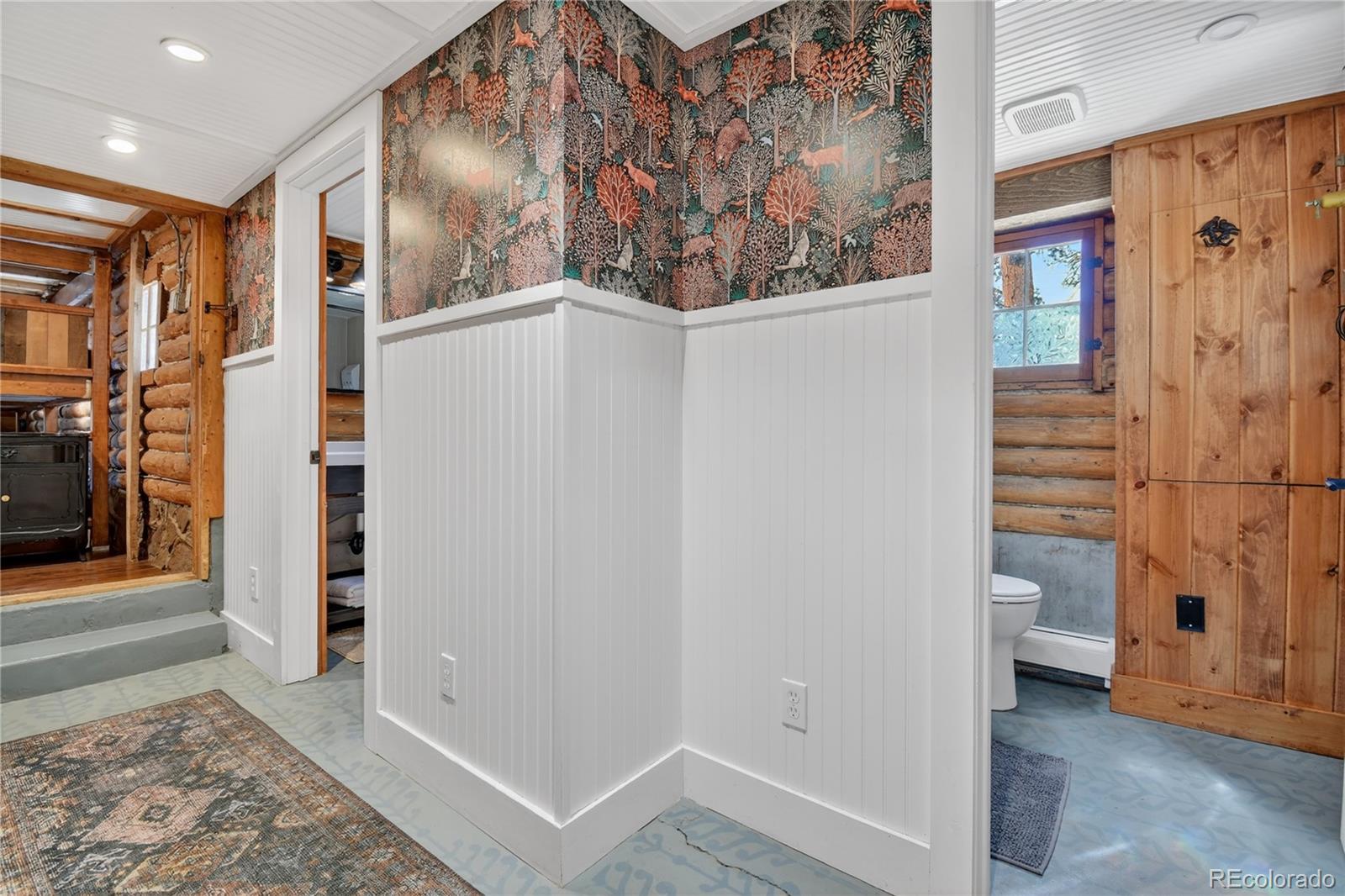 23301 Shoshone Road Indian Hills, CO 80454 - Photo 14 of 32 a view of a hallway with paintings on the wall