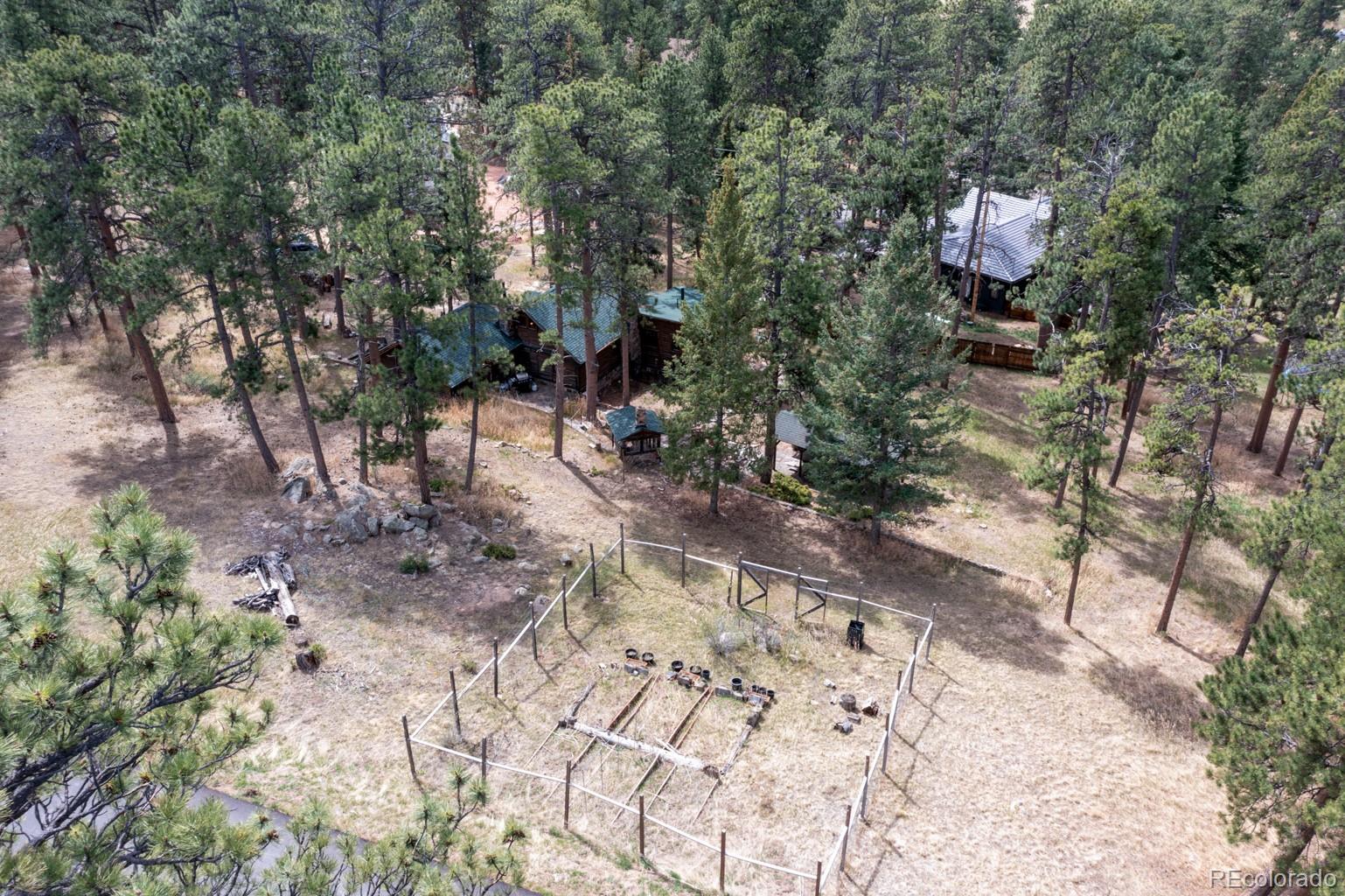 23301 Shoshone Road Indian Hills, CO 80454 - Photo 21 of 32 a front view of a house with a yard