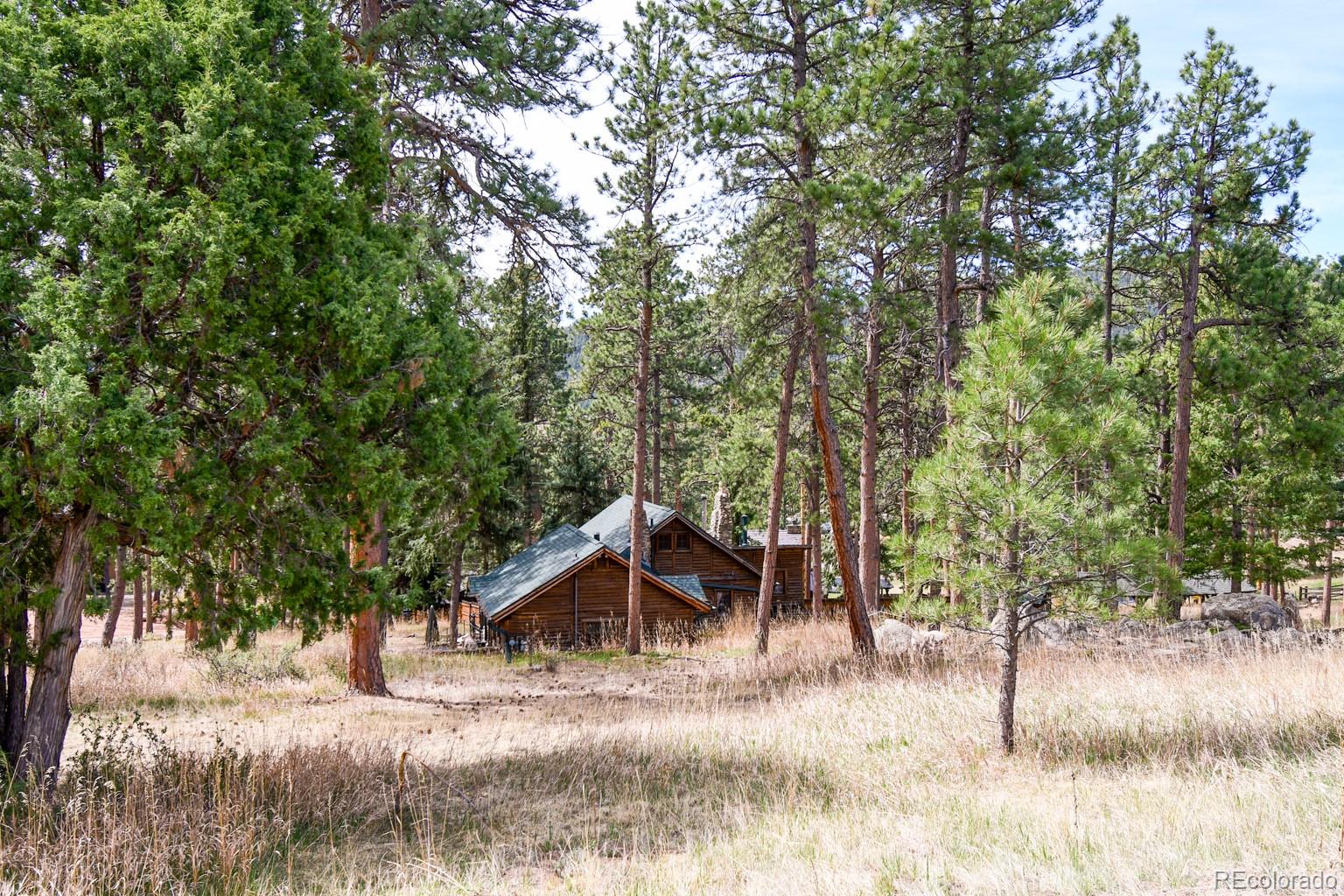 23301 Shoshone Road Indian Hills, CO 80454 - Photo 26 of 32 a view of a wooden house with a yard