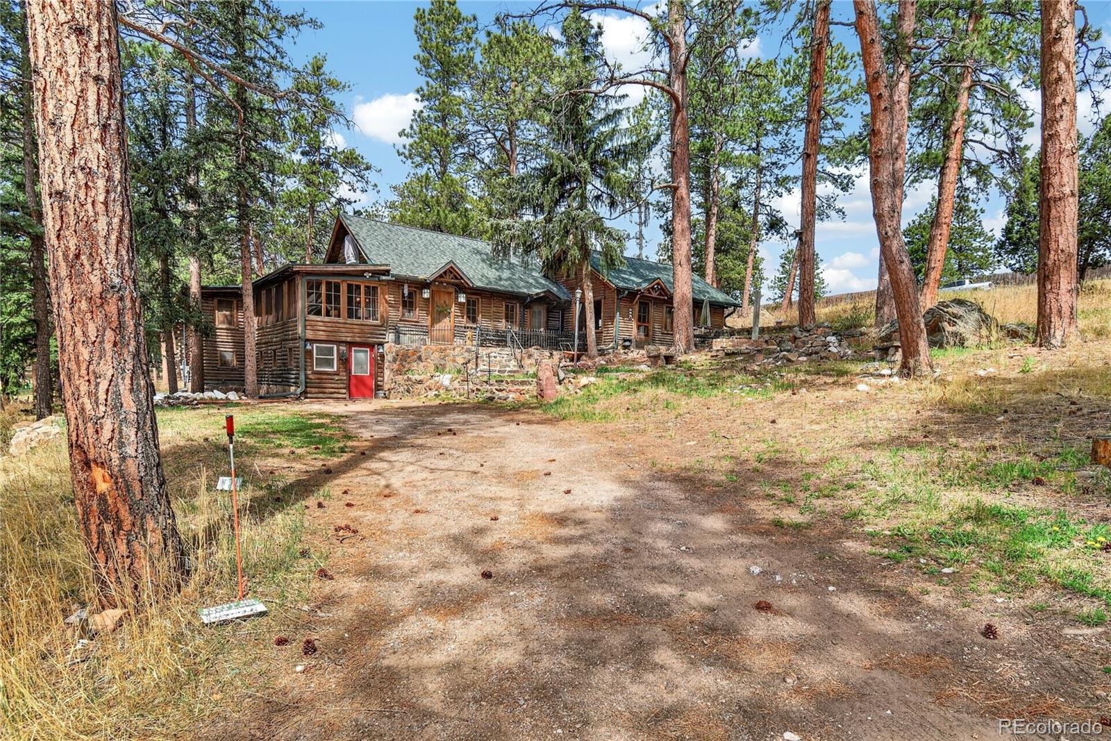23301 Shoshone Road Indian Hills, CO 80454 - Photo 29 of 32 a view of a white house with a snow on the road