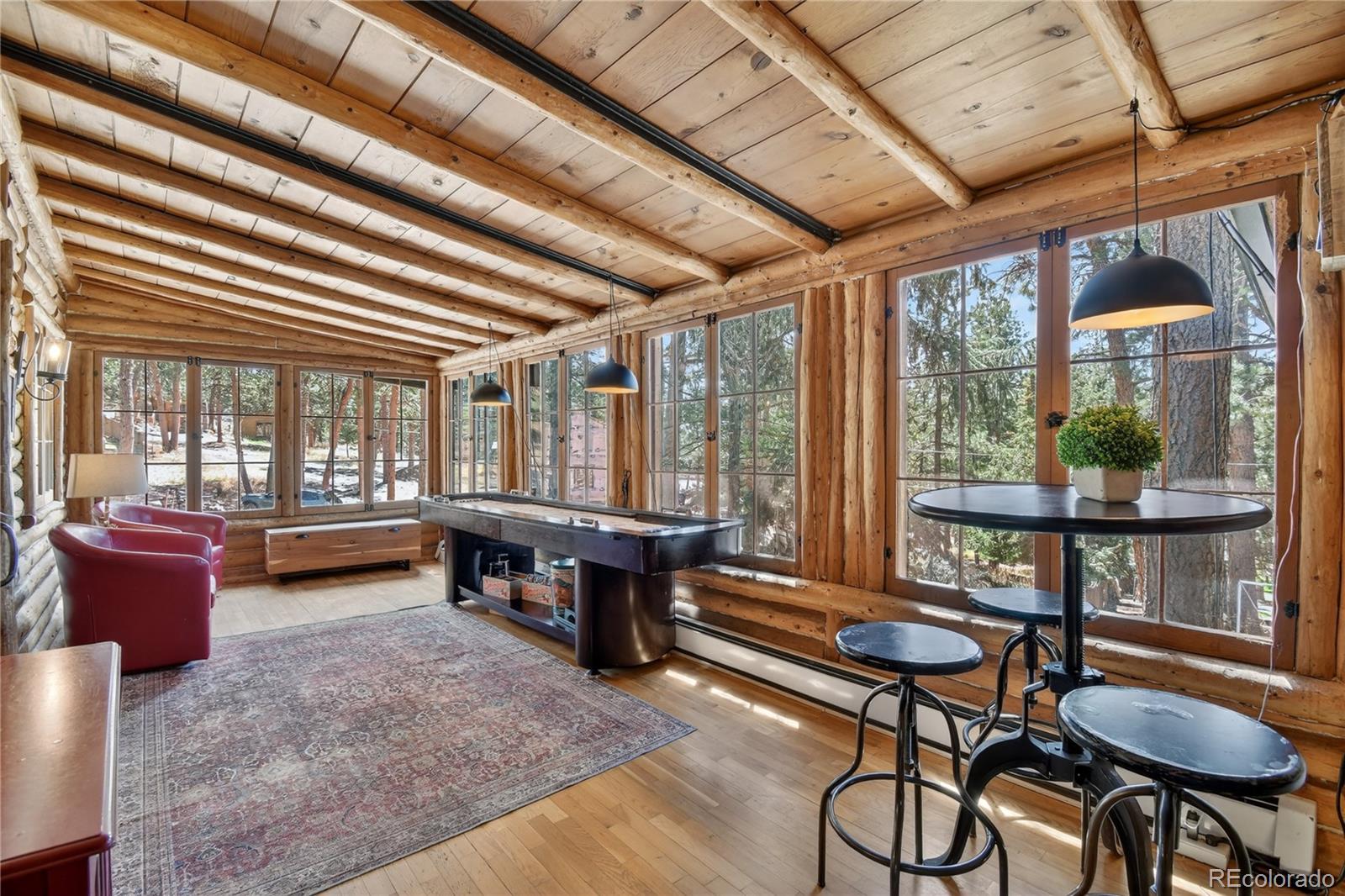 23301 Shoshone Road Indian Hills, CO 80454 - Photo 6 of 32 a living room with furniture and a large window