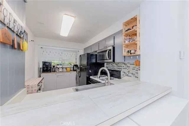 a kitchen with stainless steel appliances kitchen island sink stove and refrigerator