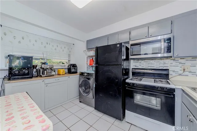 a kitchen with a refrigerator and a stove top oven