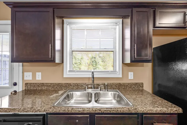 a kitchen with granite countertop a sink and a window