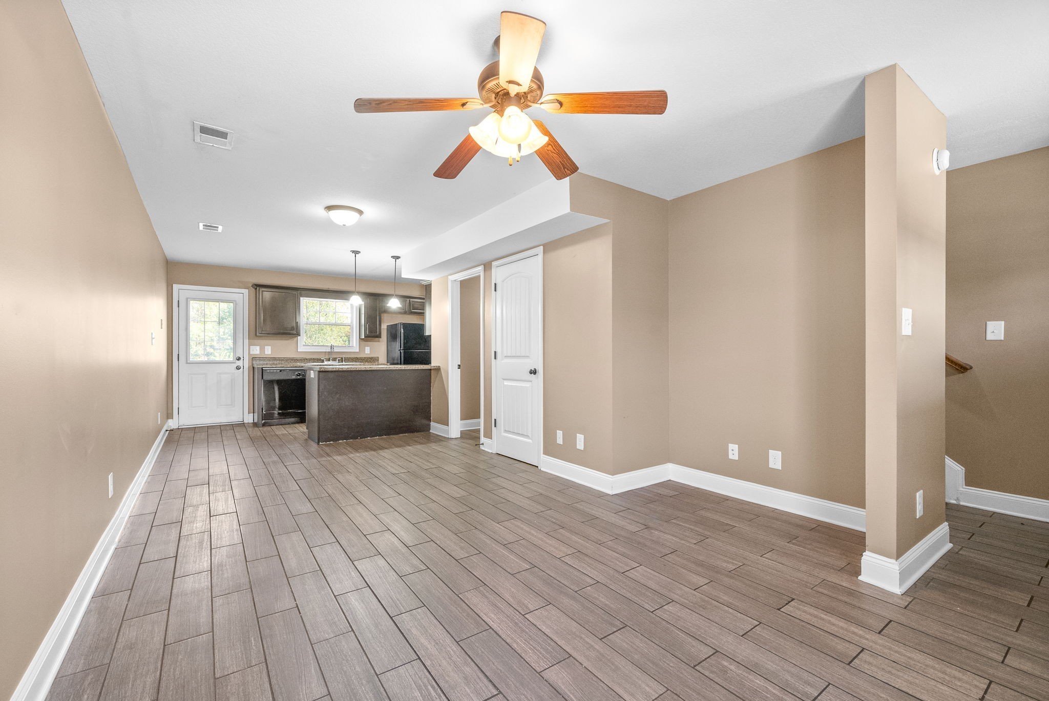 1769 Spring Water Drive, Unit C Clarksville, TN 37040 - Photo 6 of 25 a view of a big room with wooden floor a ceiling fan and windows