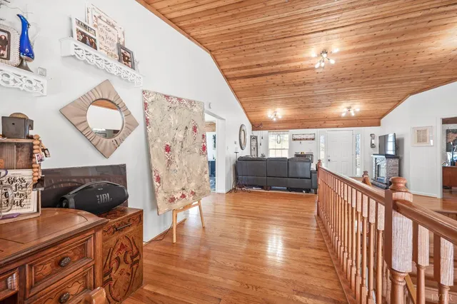 a view of a house with a yard plants and a large tree