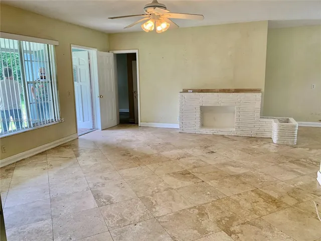 a view of an empty room with window and bathroom