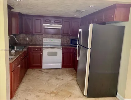 a kitchen with stainless steel appliances granite countertop a refrigerator stove a sink and a oven