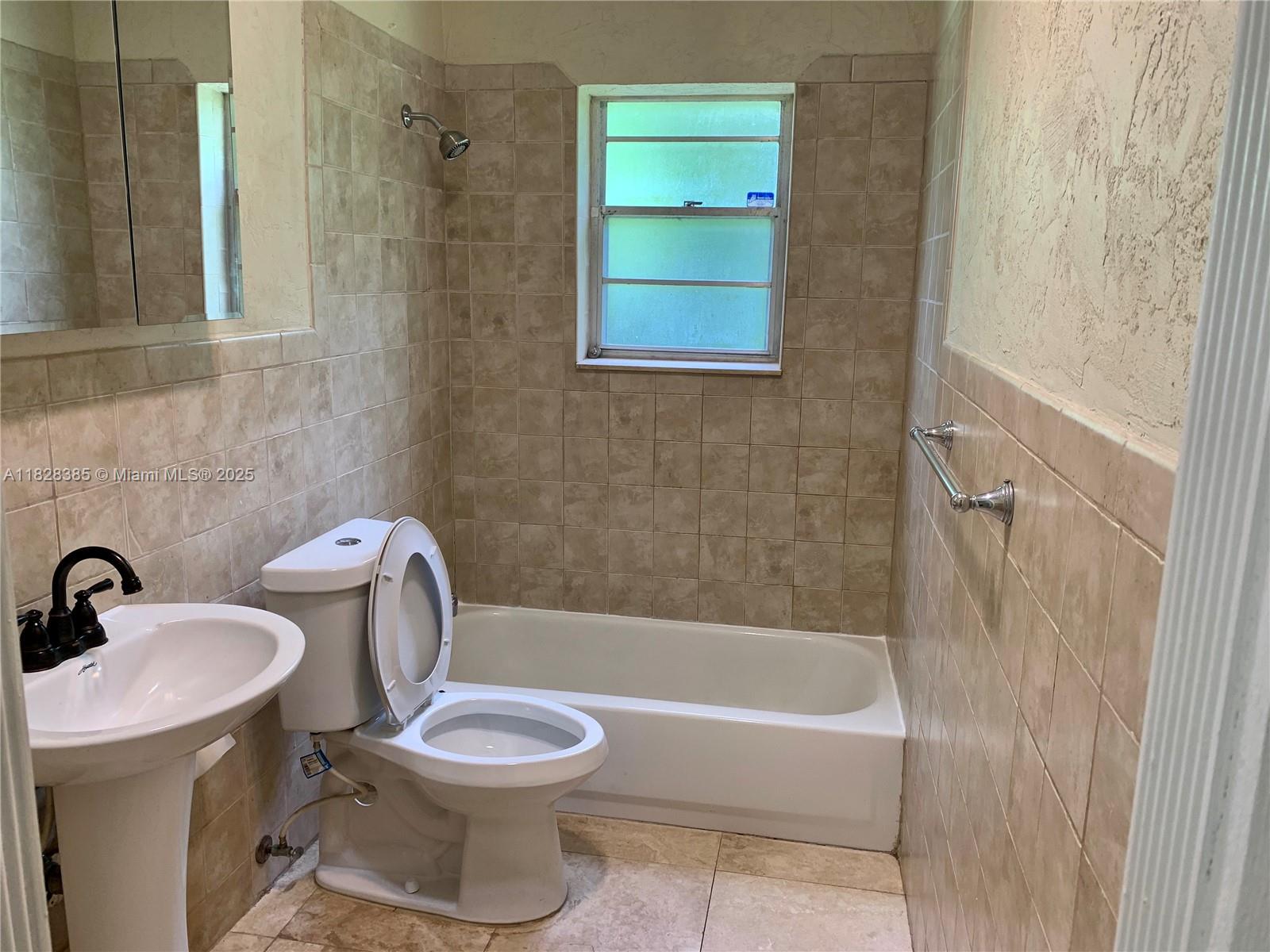 5221 Orange Drive Davie, FL 33314 - Photo 8 of 19 a white toilet sitting next to a bath tub
