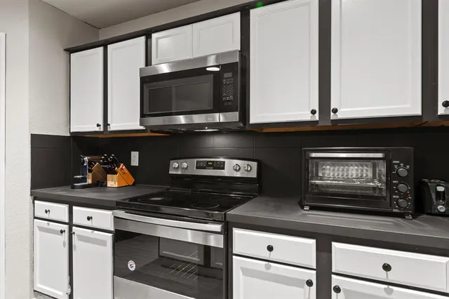 a kitchen with stainless steel appliances granite countertop a stove and a microwave