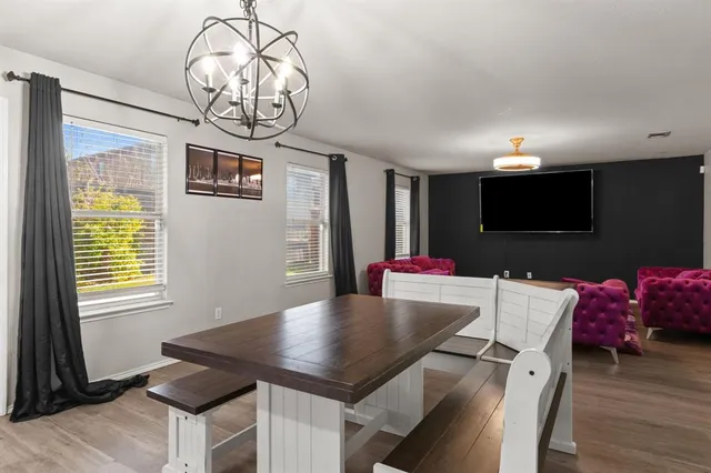 a view of a dining room with furniture a chandelier and wooden floor