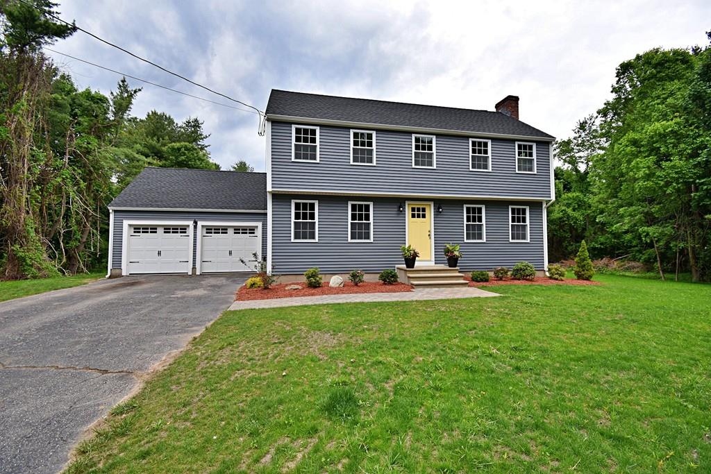 a front view of a house with yard and green space