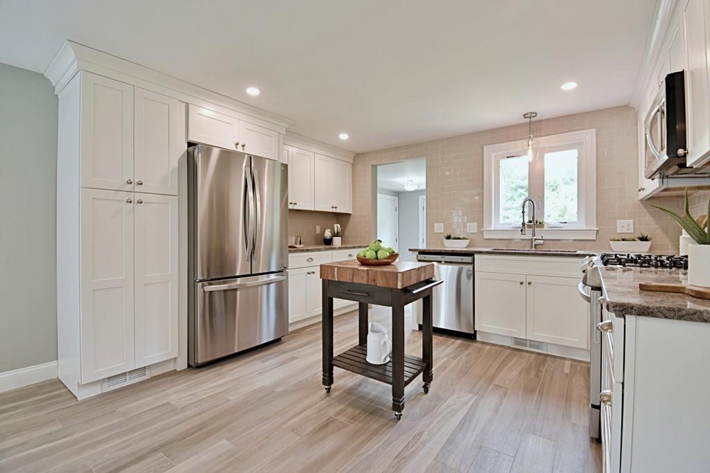 65 Spaulding Road Chelmsford, MA 01824 - Photo 5 of 42 a kitchen with a refrigerator a sink dishwasher a stove and white cabinets with wooden floor