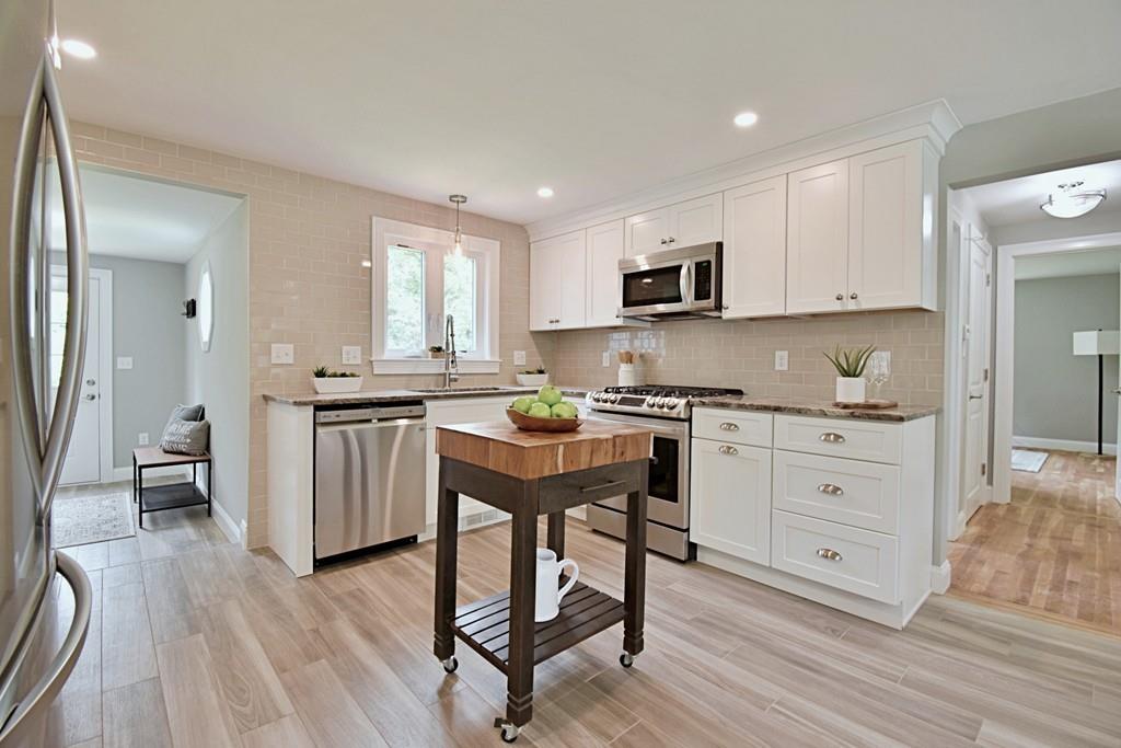 65 Spaulding Road Chelmsford, MA 01824 - Photo 7 of 42 a kitchen with white cabinets and stainless steel appliances