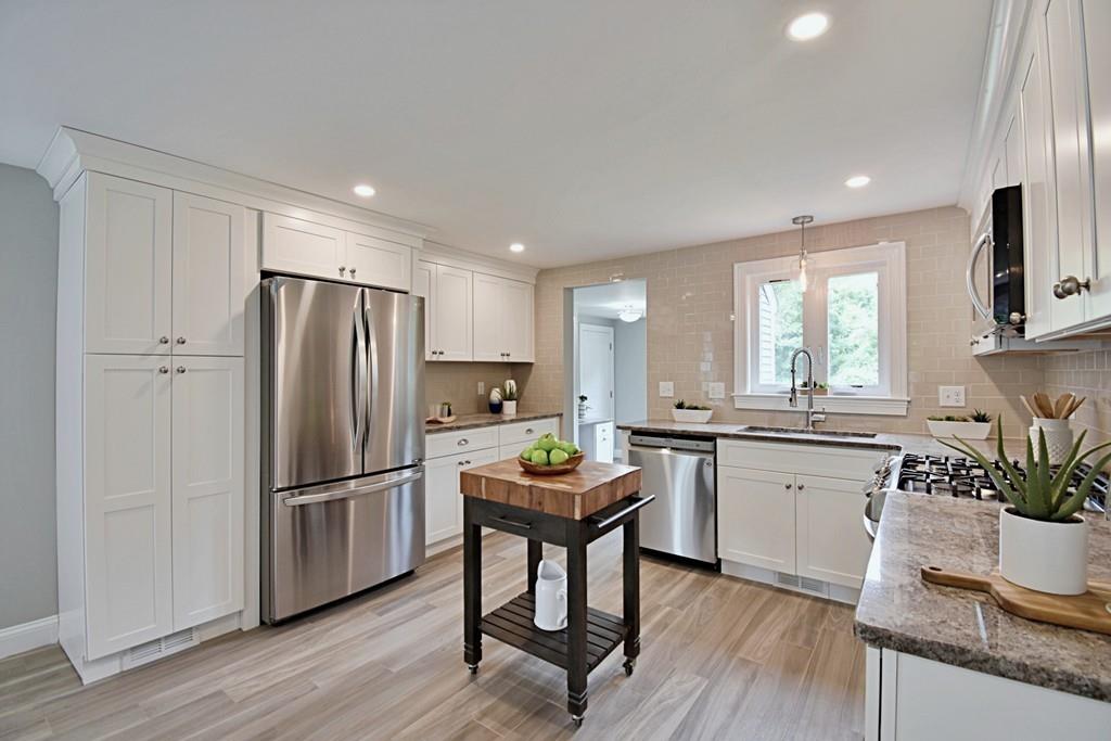 65 Spaulding Road Chelmsford, MA 01824 - Photo 8 of 42 a kitchen with stainless steel appliances granite countertop refrigerator cabinets dining table and chairs