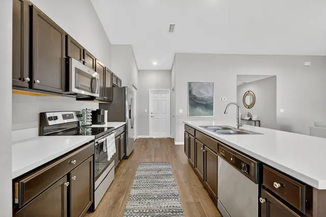 a kitchen with stainless steel appliances granite countertop a sink stove and cabinets