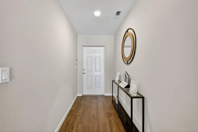 a view of a hallway with wooden floor