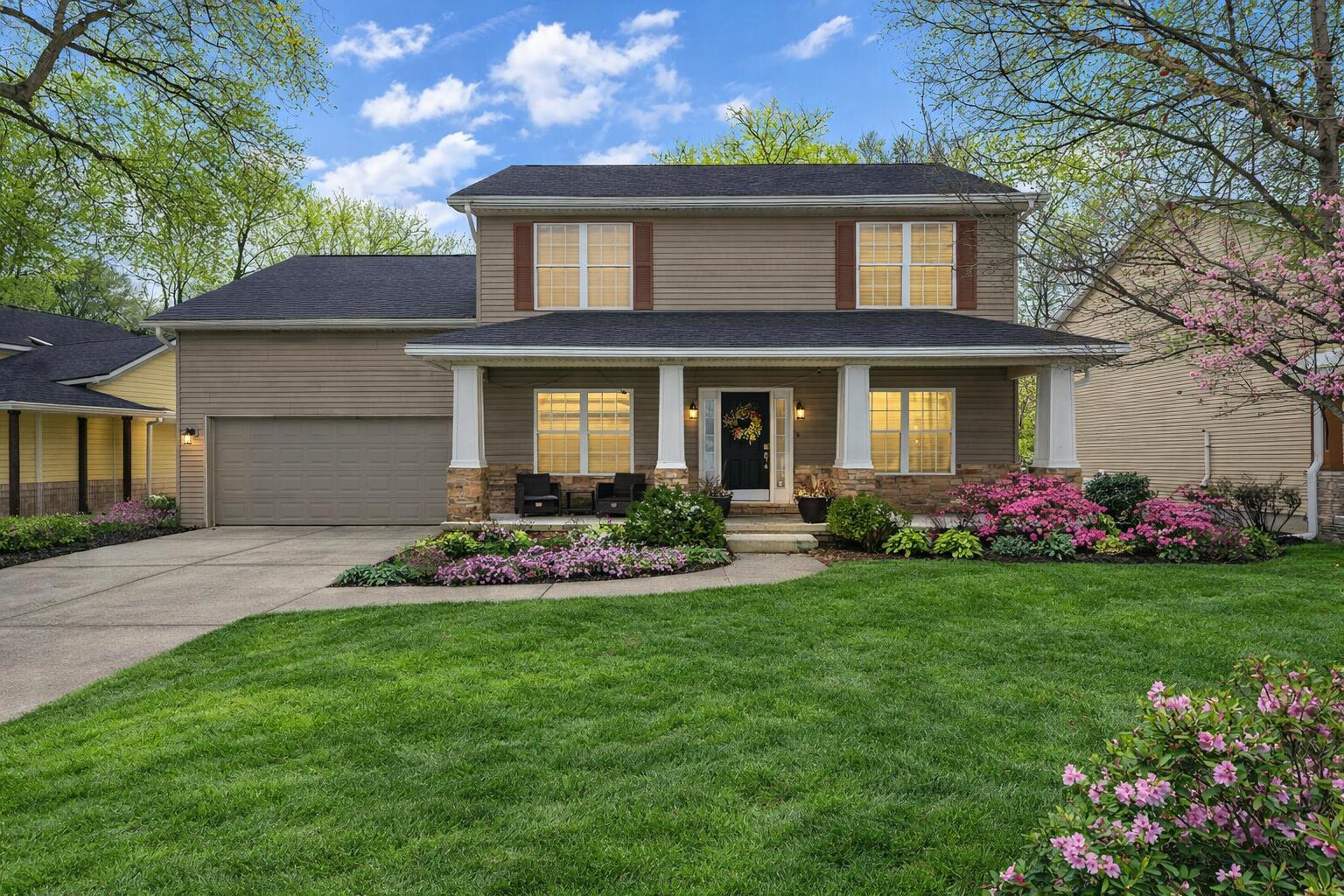 a front view of a house with a garden and yard