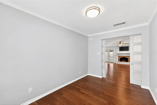 a view of empty room with wooden floor and window