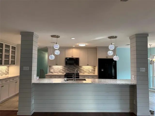 a kitchen with kitchen island a sink stainless steel appliances and cabinets