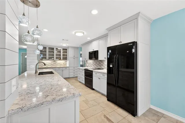 a kitchen with granite countertop a refrigerator oven a sink and dishwasher