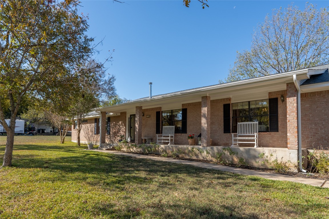 Ranch-style home featuring covered porch, a front yard, and brick siding