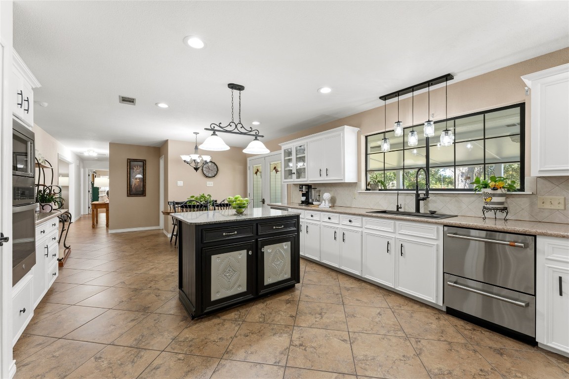 306 Starview Drive Georgetown, TX 78628 - Photo 25 of 26 Kitchen with white cabinetry, granite countertops, decorative light fixtures, recessed lighting, and backsplash
