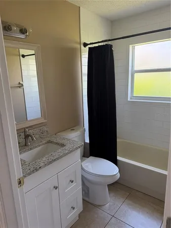 a bathroom with a granite countertop toilet sink and shower