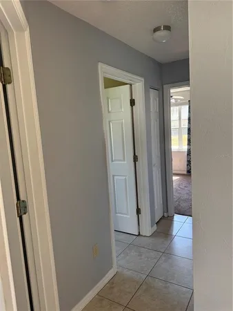 a view of a hallway with wooden floor and a bathroom