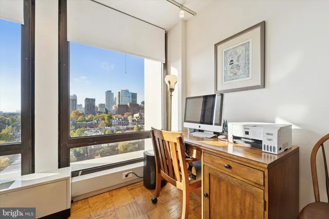 a view of a workspace with furniture and a window