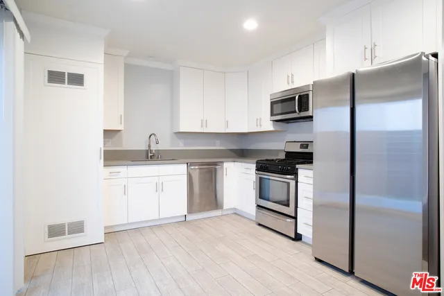 a kitchen with stainless steel appliances a refrigerator stove and microwave