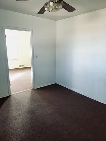 an empty room with a kitchen space and a window