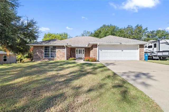 a front view of a house with a yard and trees