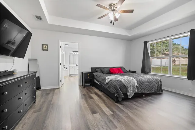 a spacious bedroom with a bed and a flat screen tv