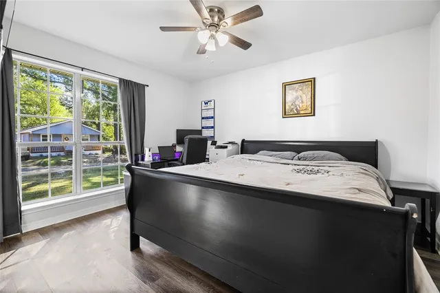 a living room with hard wood floors and a bed