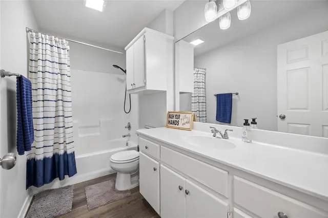 a spacious bathroom with a double vanity sink toilet and shower