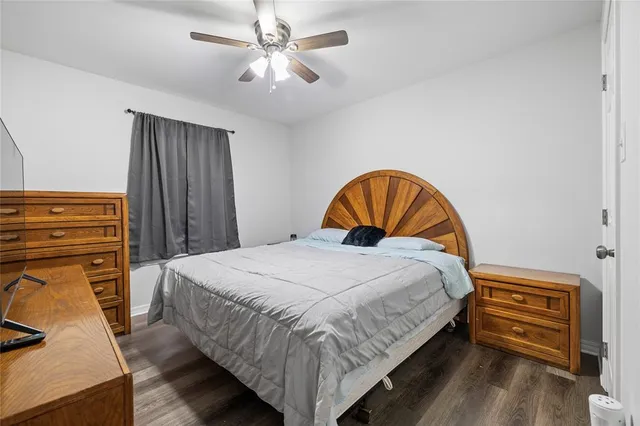 a bedroom with a bed a dresser and flowerpot