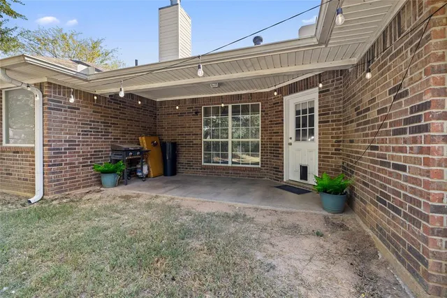 a view of a house with a yard and potted plants