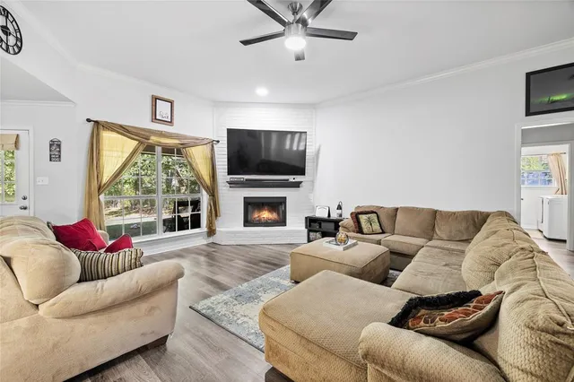 a living room with furniture a flat screen tv and a fireplace
