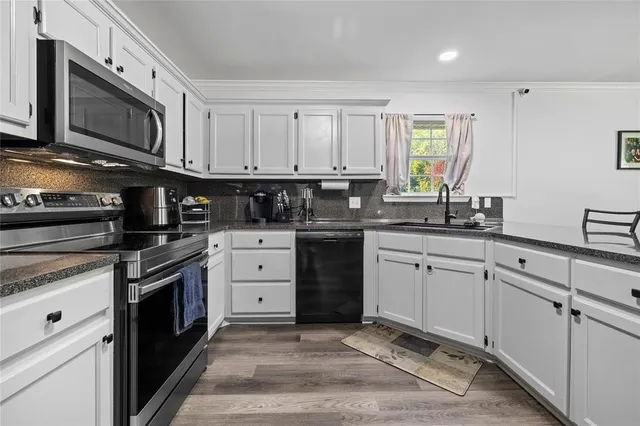 a kitchen with cabinets stainless steel appliances and a window