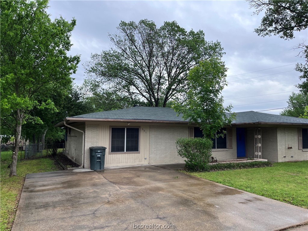 a front view of house with yard and trees