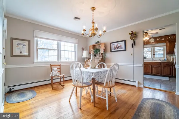 a dining room with furniture window and wooden floor