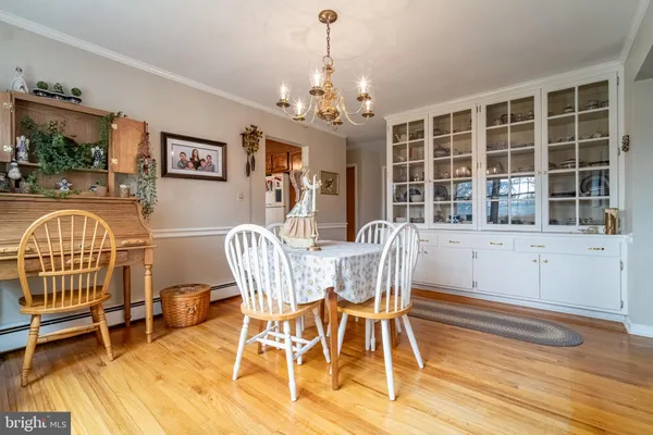 a view of a dining room with furniture a chandelier and wooden floor