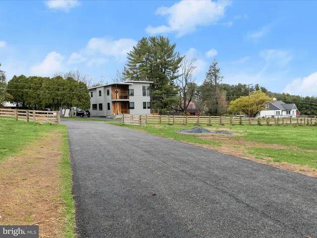 a view of a house with a big yard and large trees