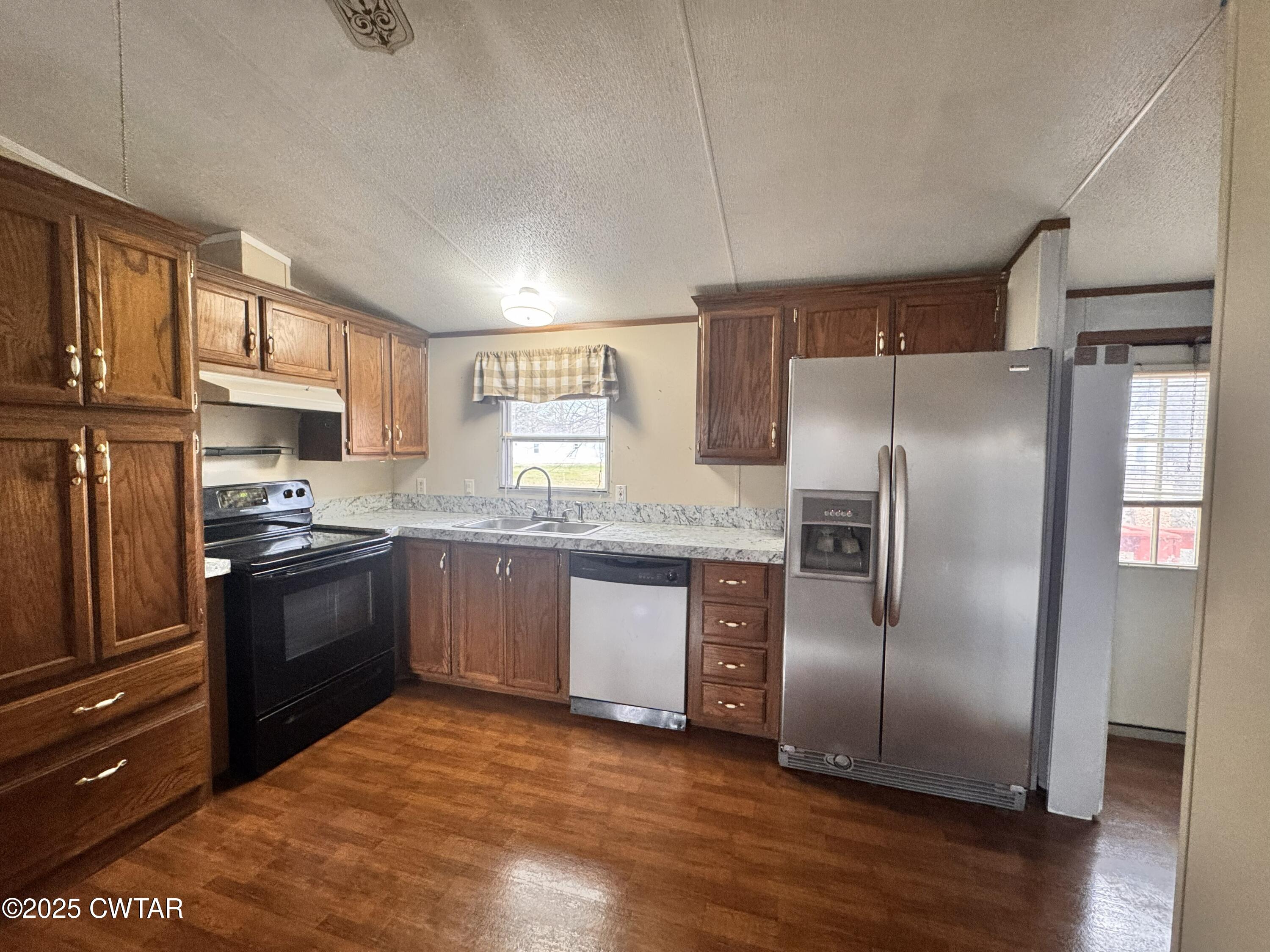 3416 West Troy Street Rives, TN 38253 - Photo 5 of 21 a kitchen with granite countertop a refrigerator and a stove top oven