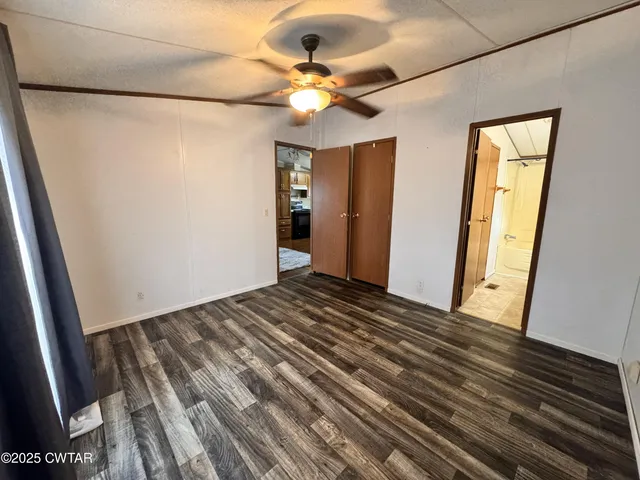 a view of a room with wooden floor and fan