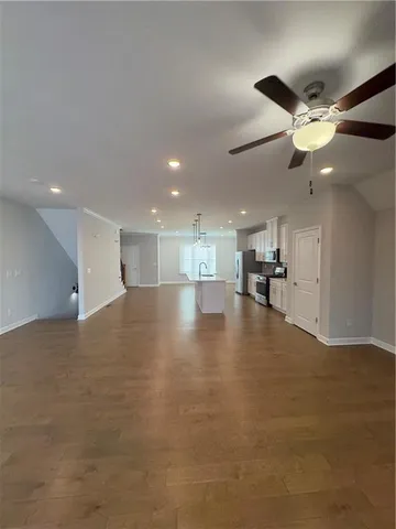 a view of empty room with wooden floor and ceiling fan