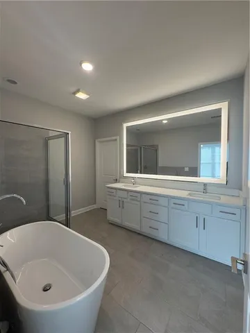 a bathroom with a bathtub sink and mirror