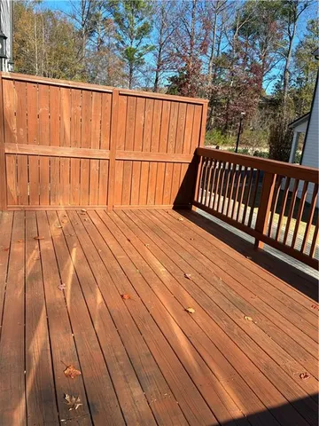 a view of balcony with wooden floor and fence