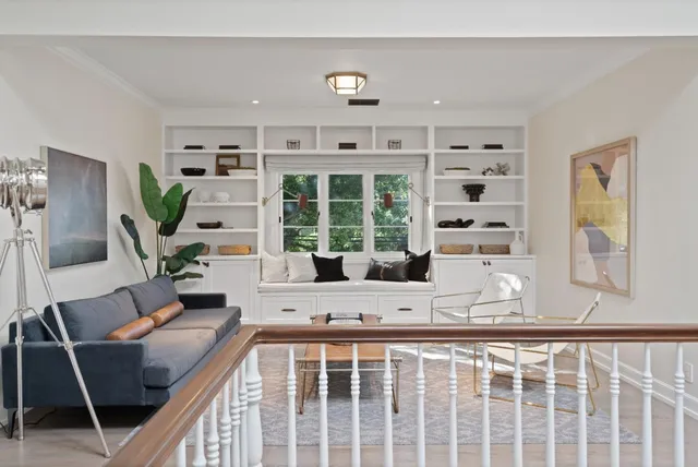 a spacious bedroom with a bed a chandelier and a window